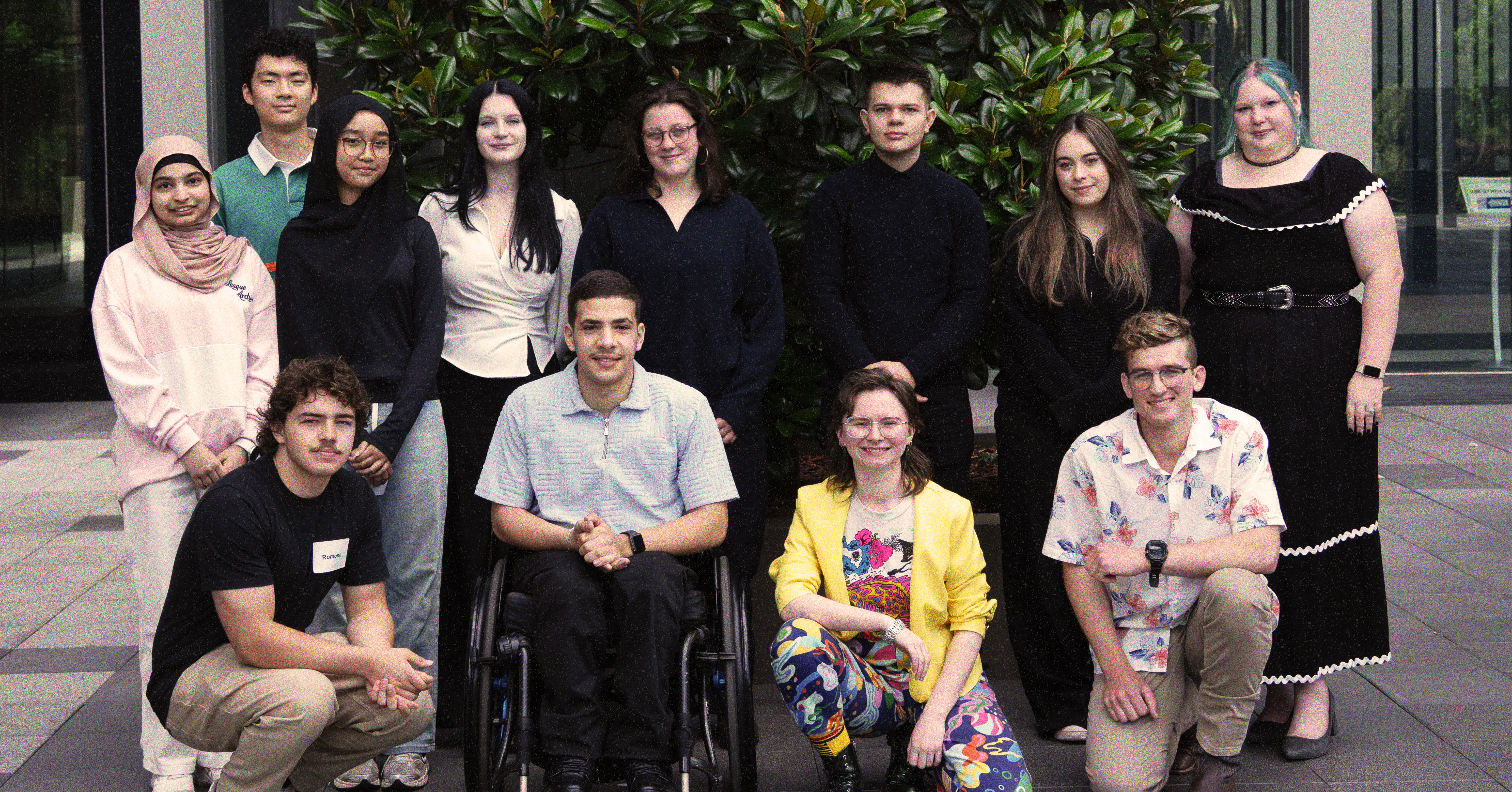 Twelve young people in three rows smiling.